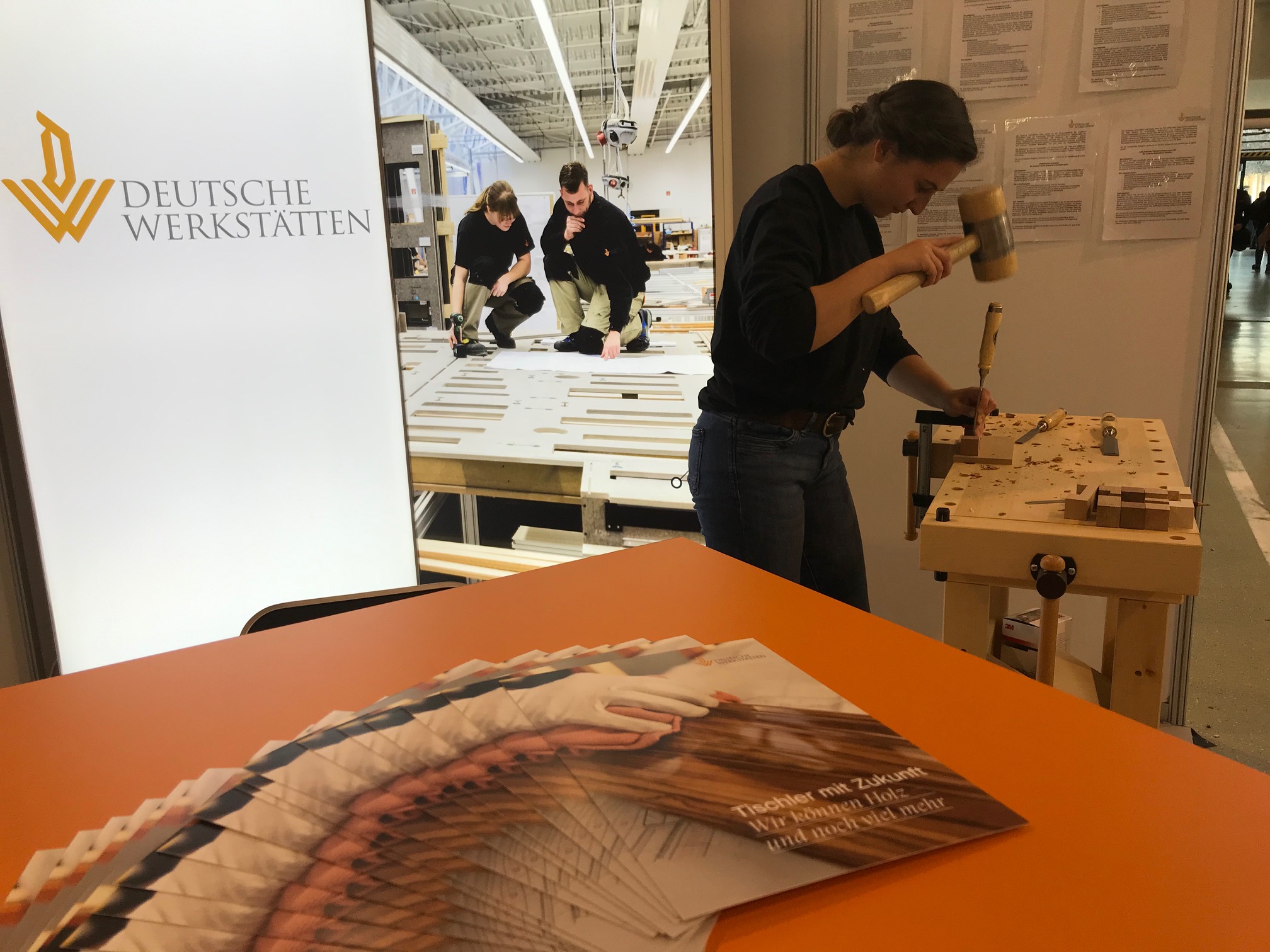 Mitarbeiter der Deutschen Werkstätten aus Dresden-Hellerau sind auf der Messe Karrierestart 2020 vertreten. Anna Weber, Auszubildende bei den Deutschen Werkstätten aus Dresden-Hellerau, arbeitet auf der Dresdner Messe Karrierestart an der Hobelbank. Foto: DW/Juliane Richter